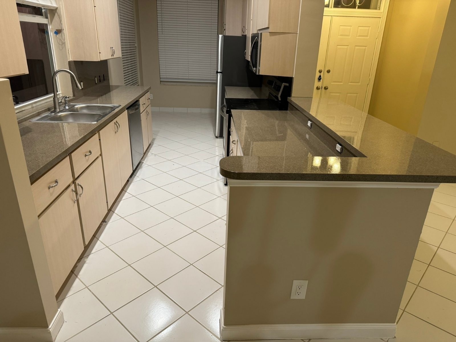 The same kitchen finished — gray granite-look counters and backsplash, masking removed