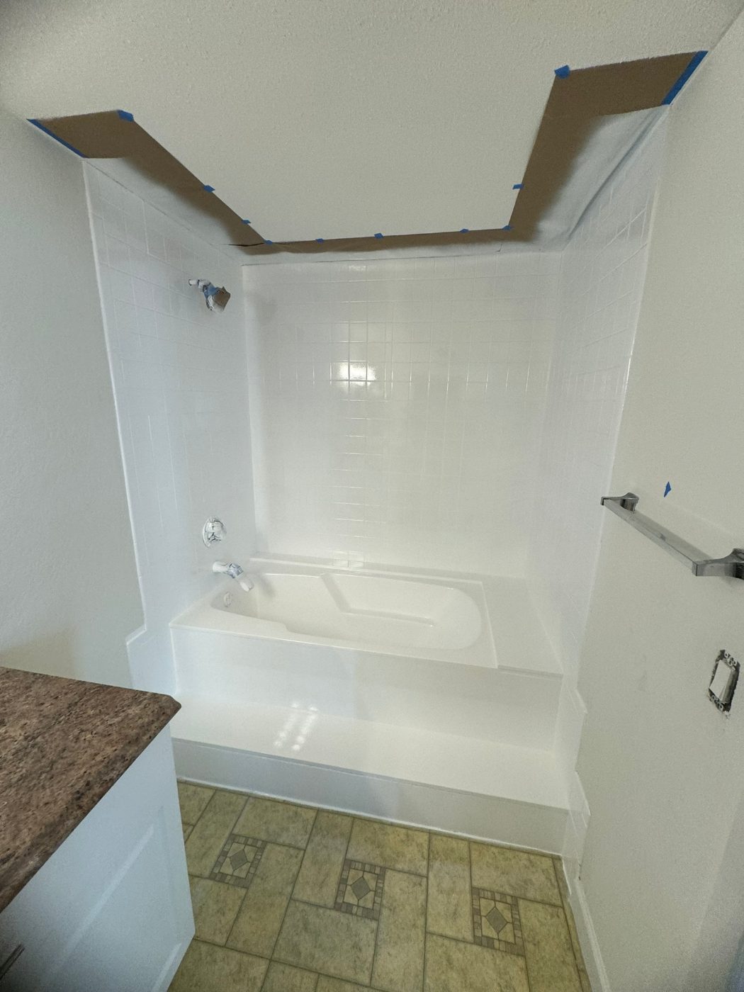 A tub surround refinished white where a dated green border stripe used to run