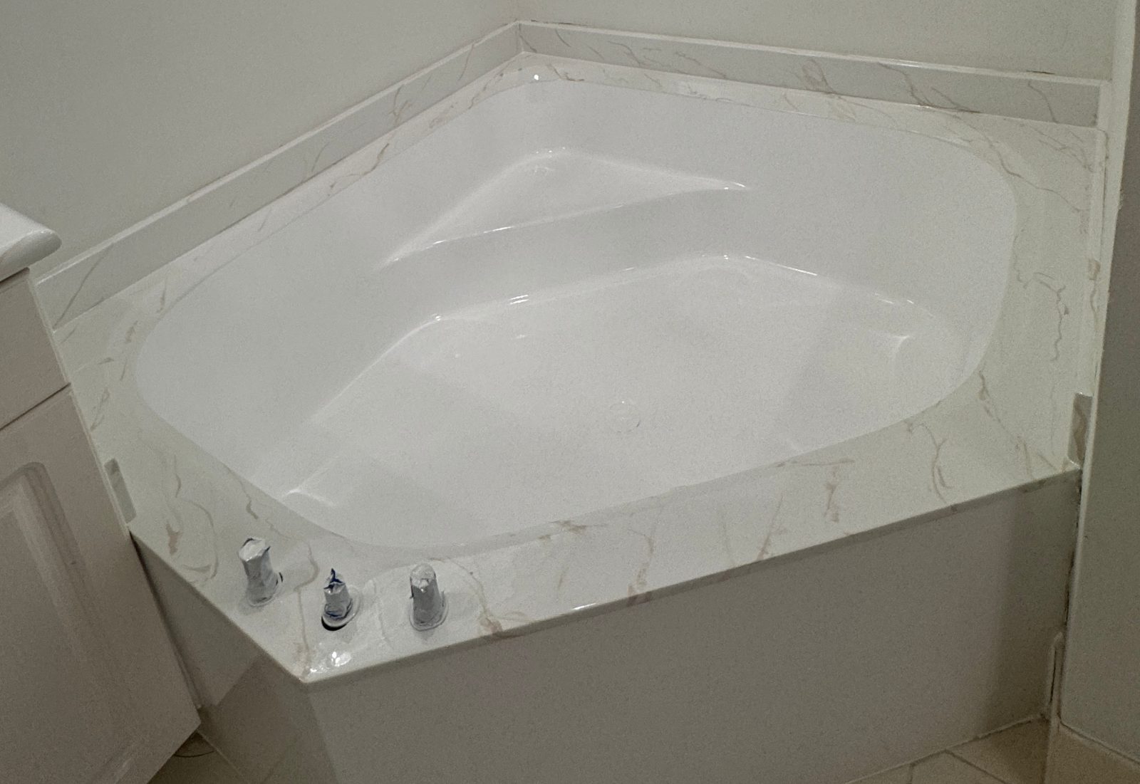 Corner tub — almond to white, marble-look deck — after