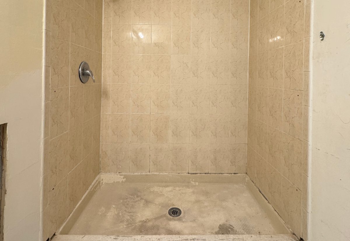 Worn shower stall, sealed & bright — before