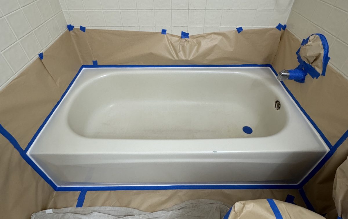 A bathtub surrounded with masking paper and tape before spraying