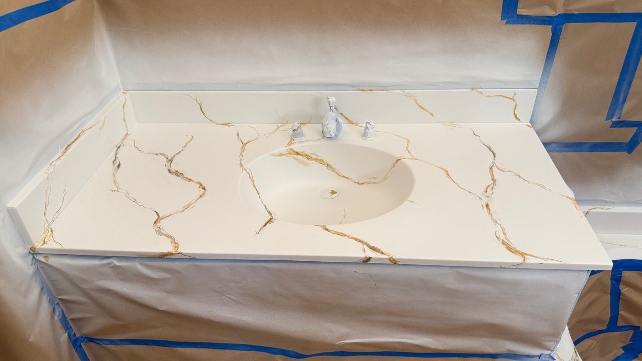 The same vanity top finished in a hand-veined gold marble imitation