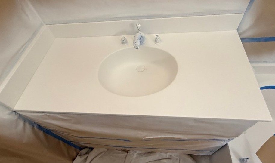 A vanity top and sink in a plain white base coat, masked for detailing