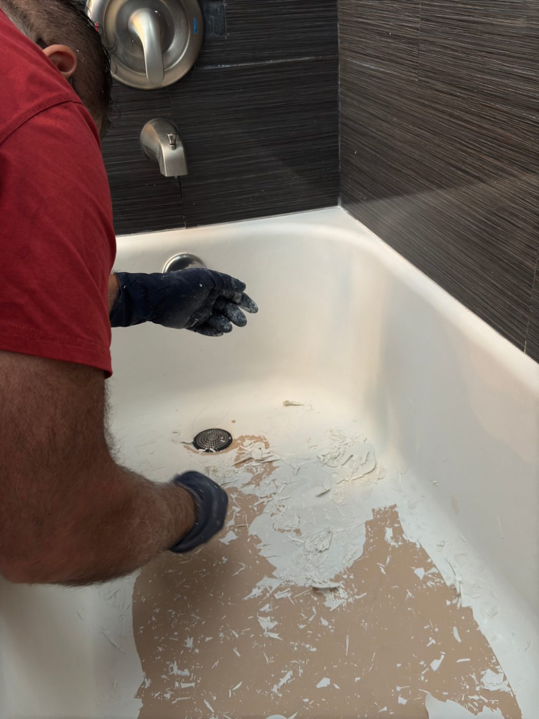 A technician repairing and prepping a bathtub before refinishing