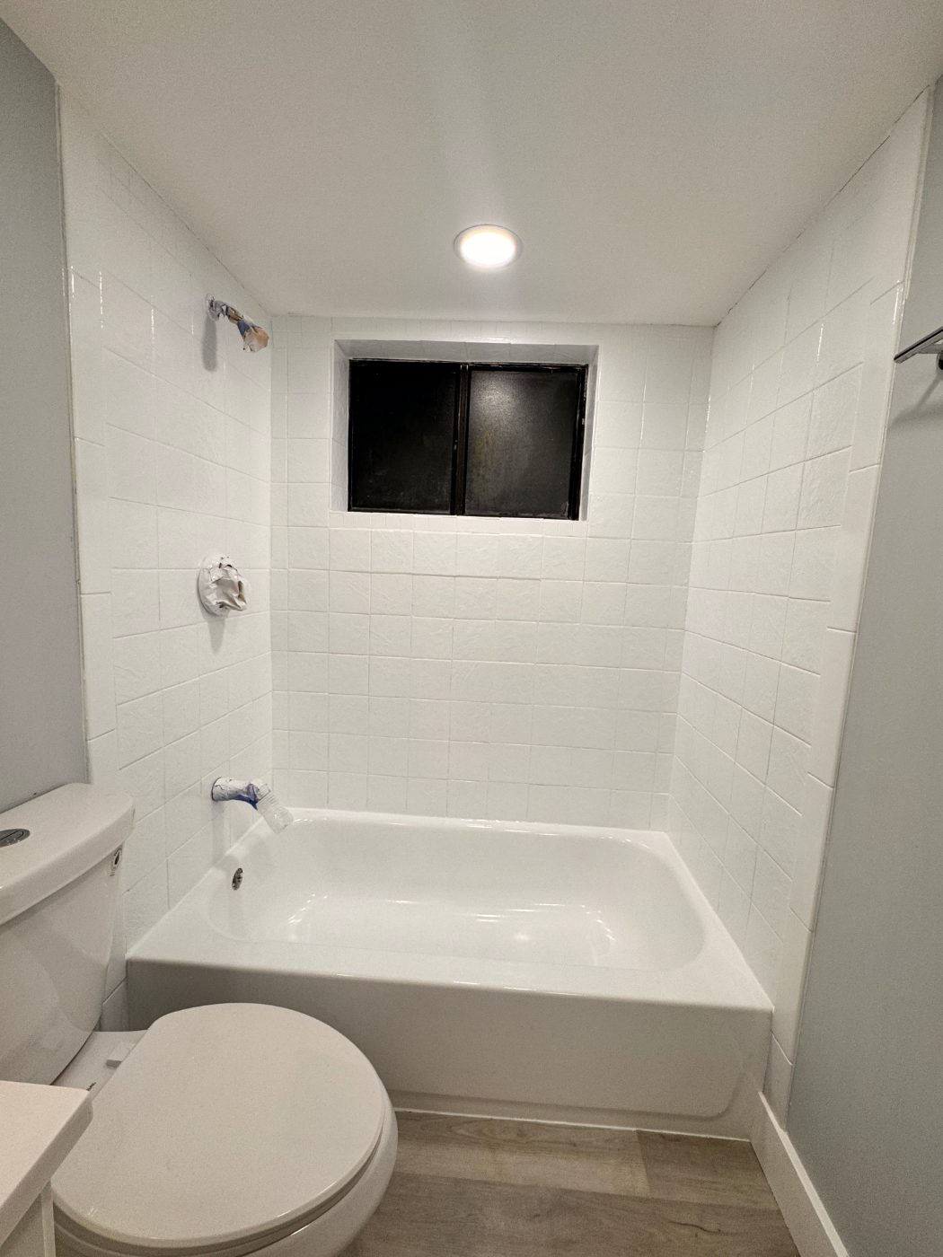 The finished alcove — tub and tile walls in one bright white finish, masking removed