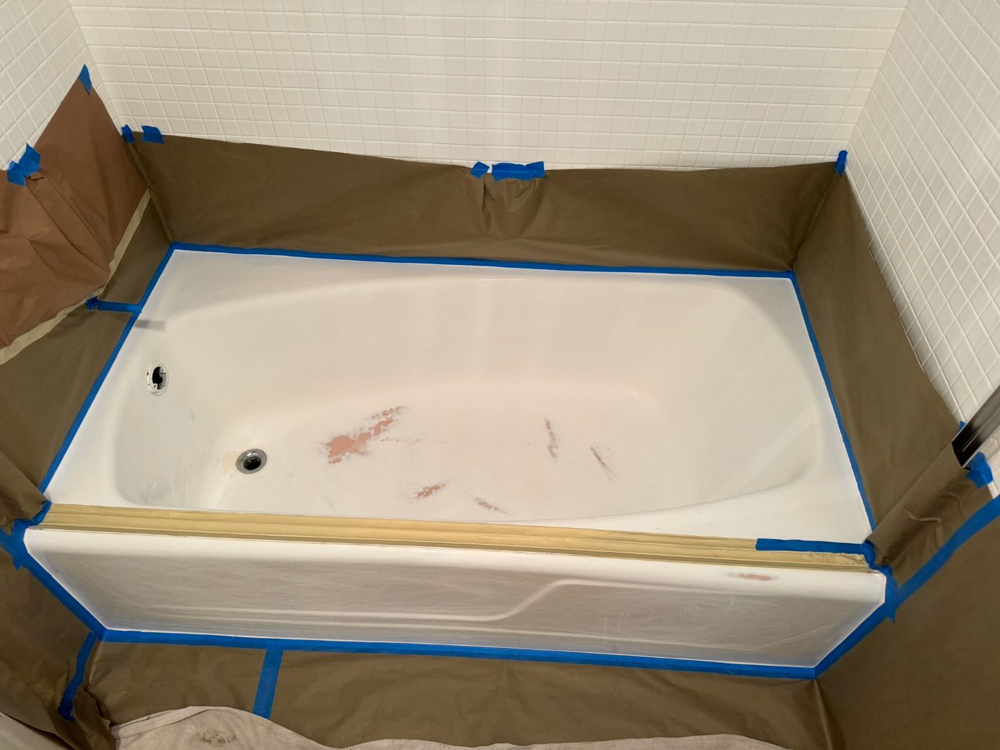 A bathtub basin with filled and patched damage spots, ready for its new finish