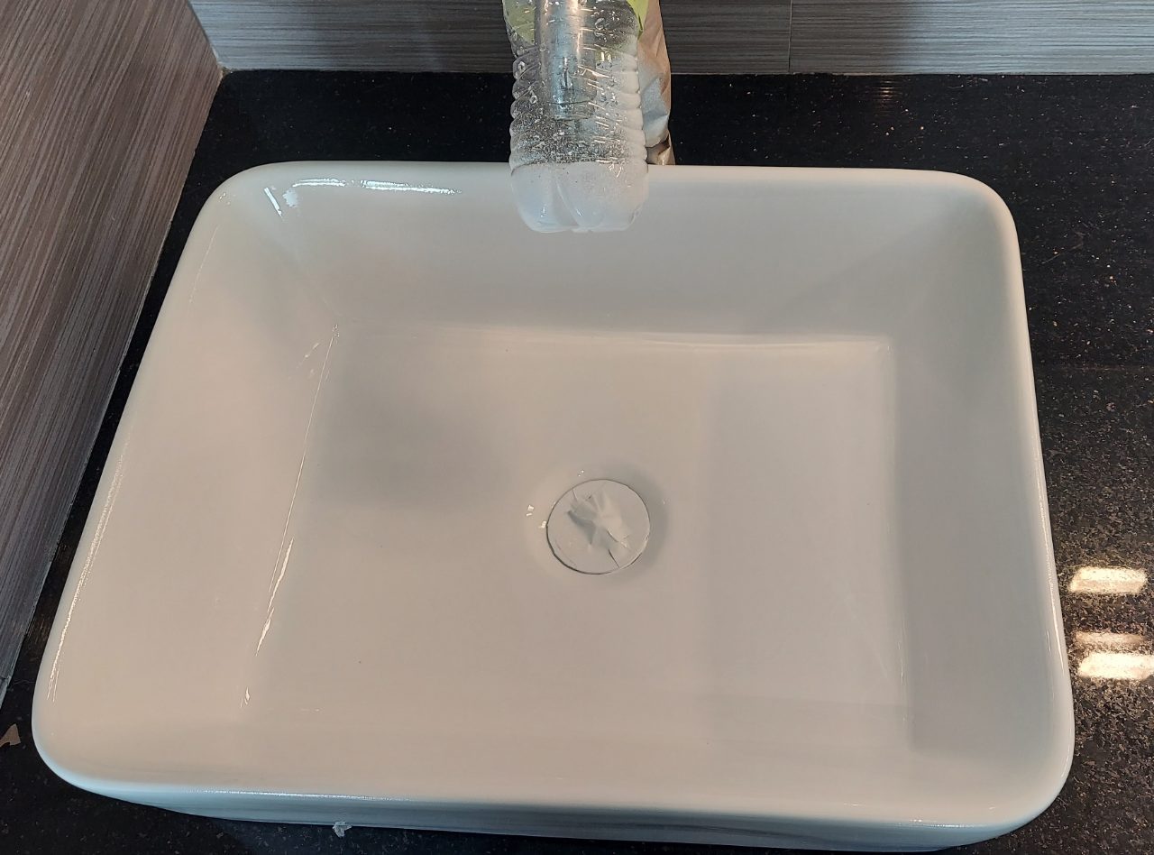 Vessel sink freshly refinished, drain still taped while the finish cures