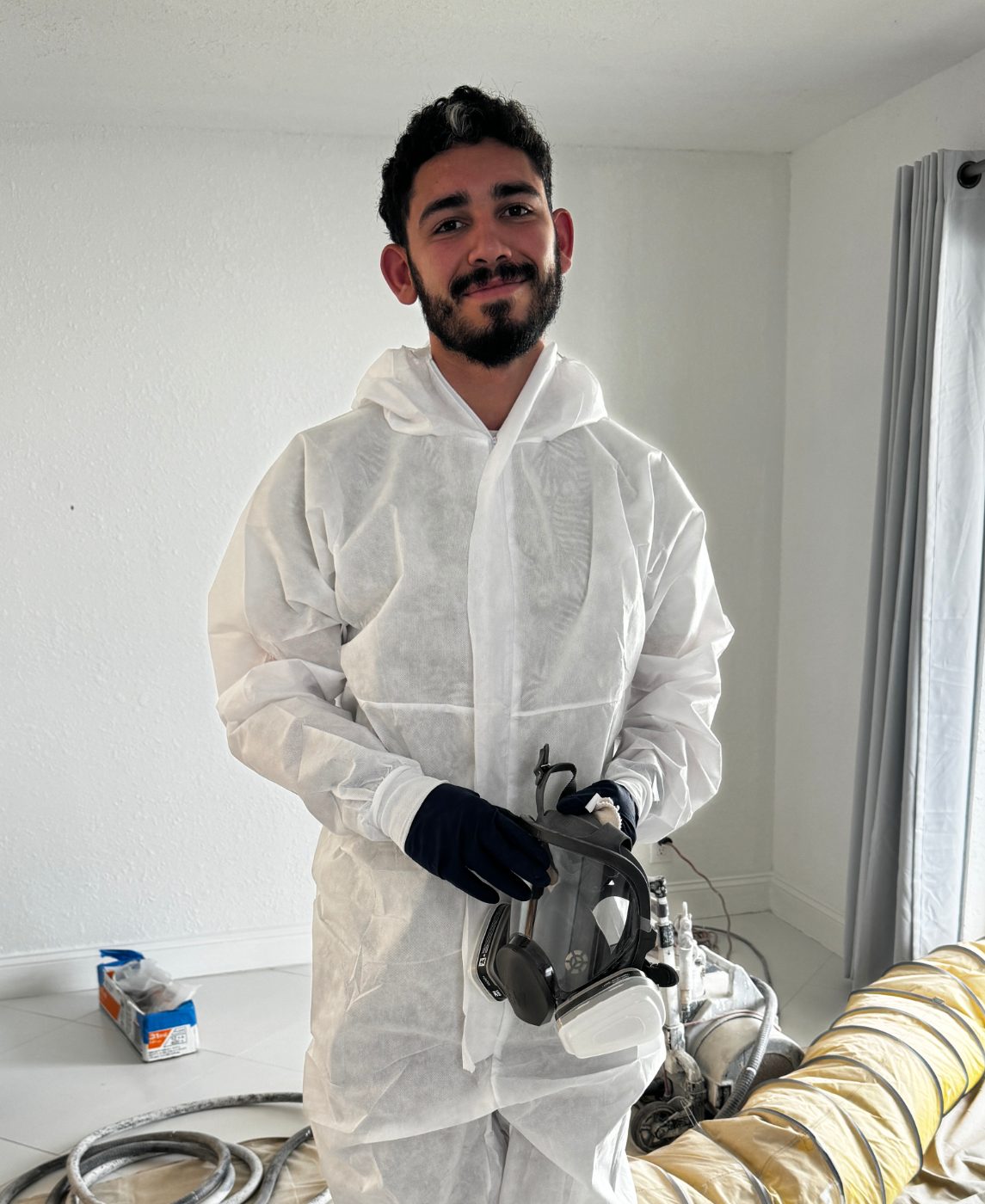 A Tub Done refinishing technician suited up on the job, holding a respirator